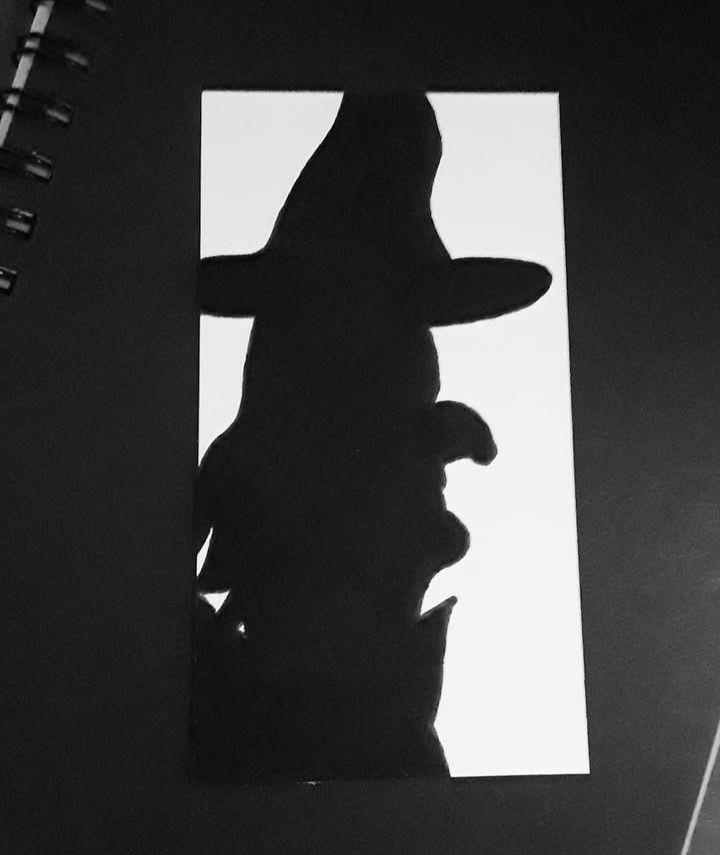 Black ink profile of a witch with a cape and hat. Or, possibly my sister. 🤷‍♀️