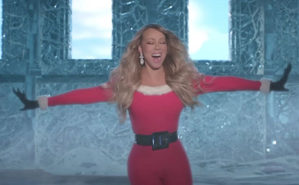 mariah carey is shown powering up for the holiday season that is quickly approaching. She is shown summoning all cheer, joy, and a mass weapon of Noel. With her eyes closed and arms outstretched at her sides she is wielding an ancient power of joy to the world we have not seen since last Christmas. 