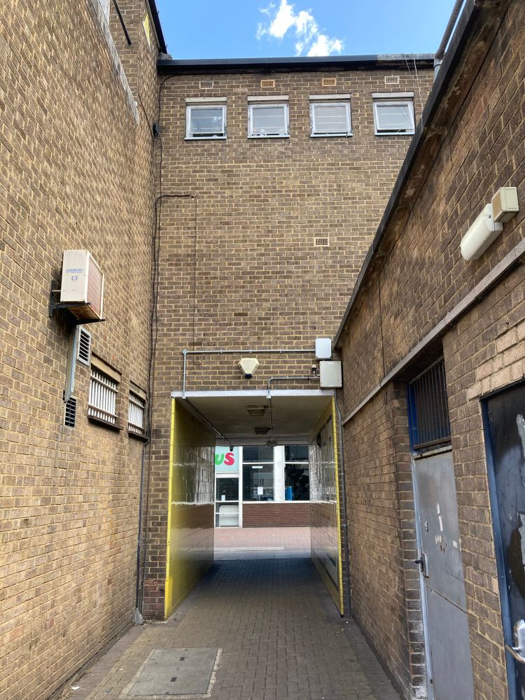 Characterful midcentury cut through alleyway, all brown brick, small square windows and a kind of high school vibe 