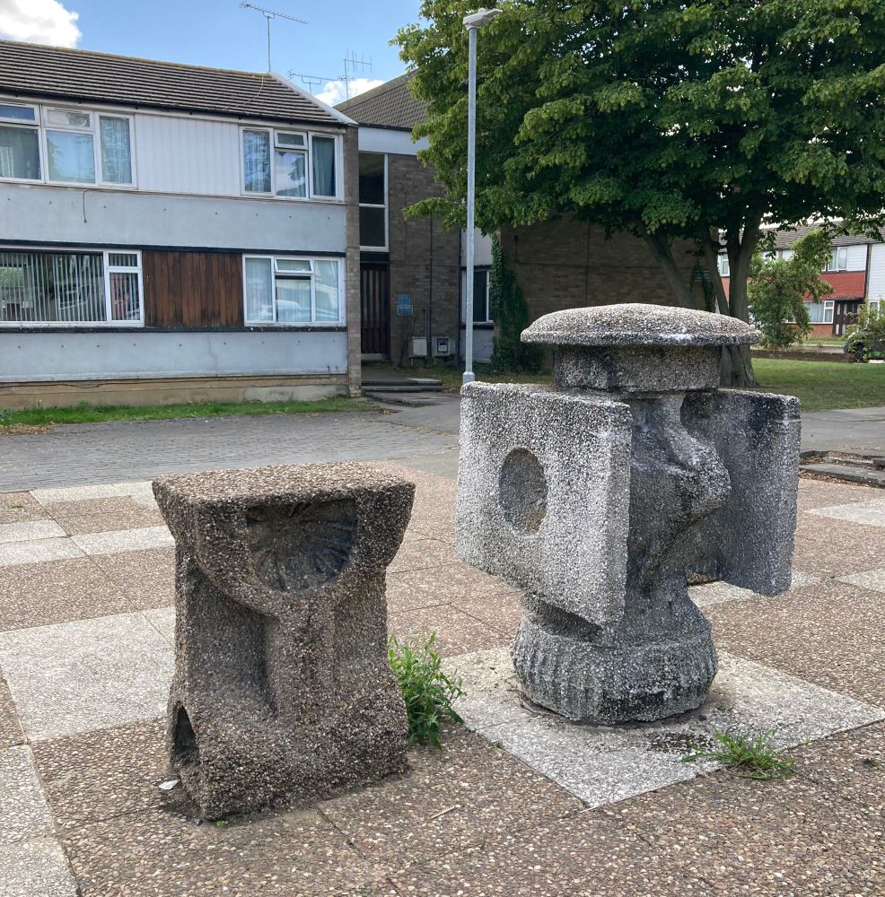 Two concrete chess pieces outside a 1960s house 