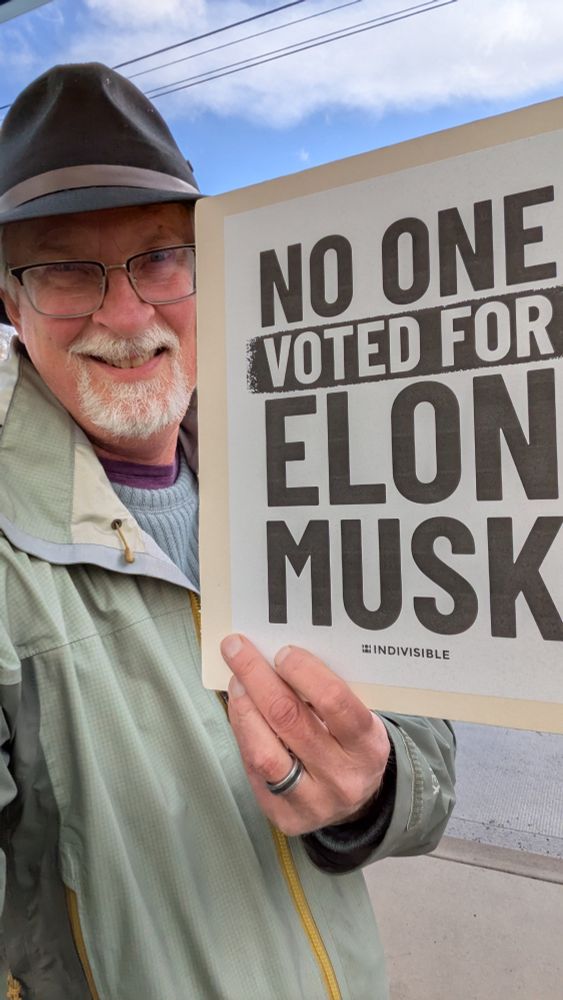 Mark holding a sign that reads "no one voted for Elon musk"