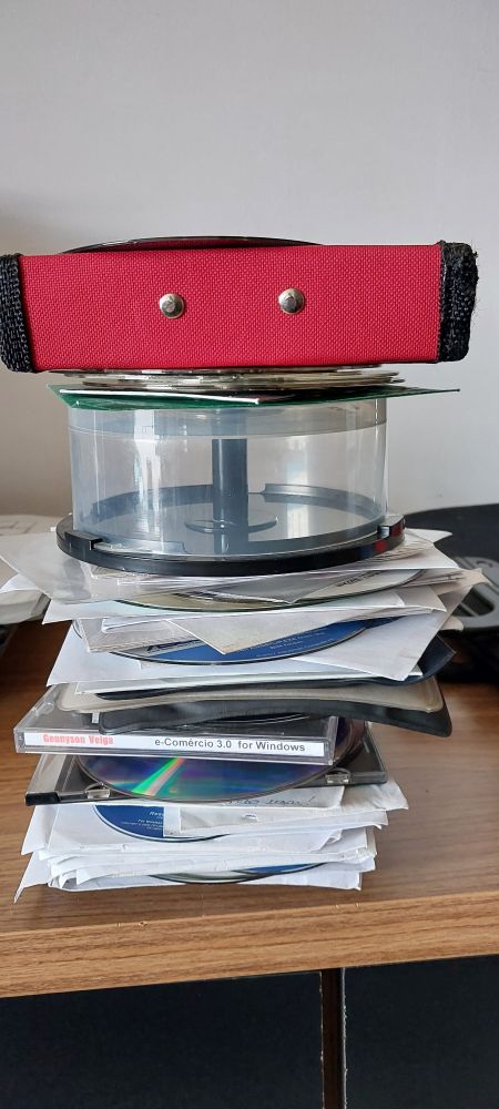 Pilha de CDs e porta CDs diversos. 