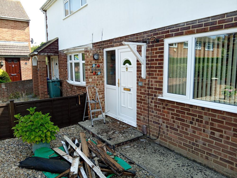 A front doorway now bereft of porch, apart from the main support, which I shall be reusing. The remains of the old porch lay in splinters on the ground. 