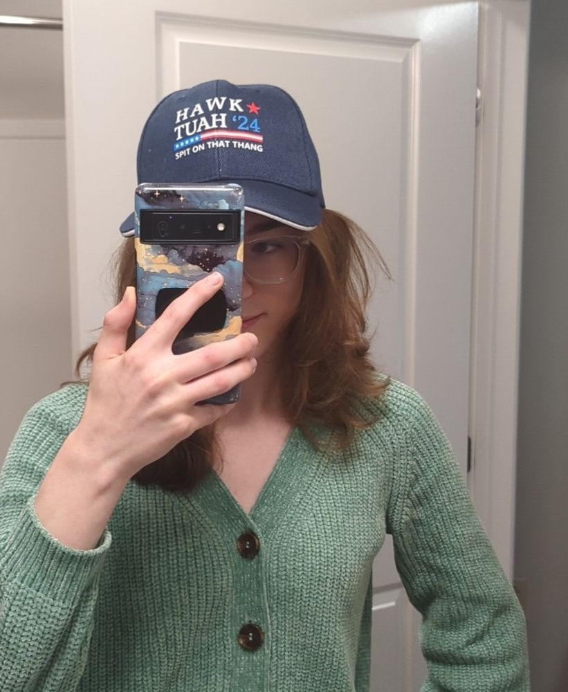 me with a hat that says "hawk tuah '24; spit on that thang" (a friend bought it for me against my will)