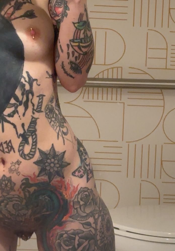 Very tattooed nude body in the bathroom