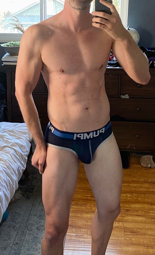 A picture of an athletic man wearing a navy blue Cruise Brief from Pump Underwear.