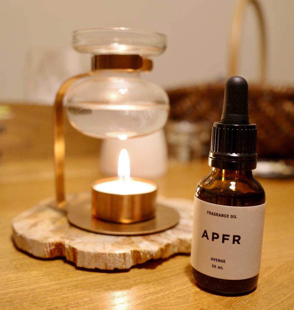 珪化木のコースターに乗ったアロマオイルウォーマーとAPFRのアロマオイルの写真