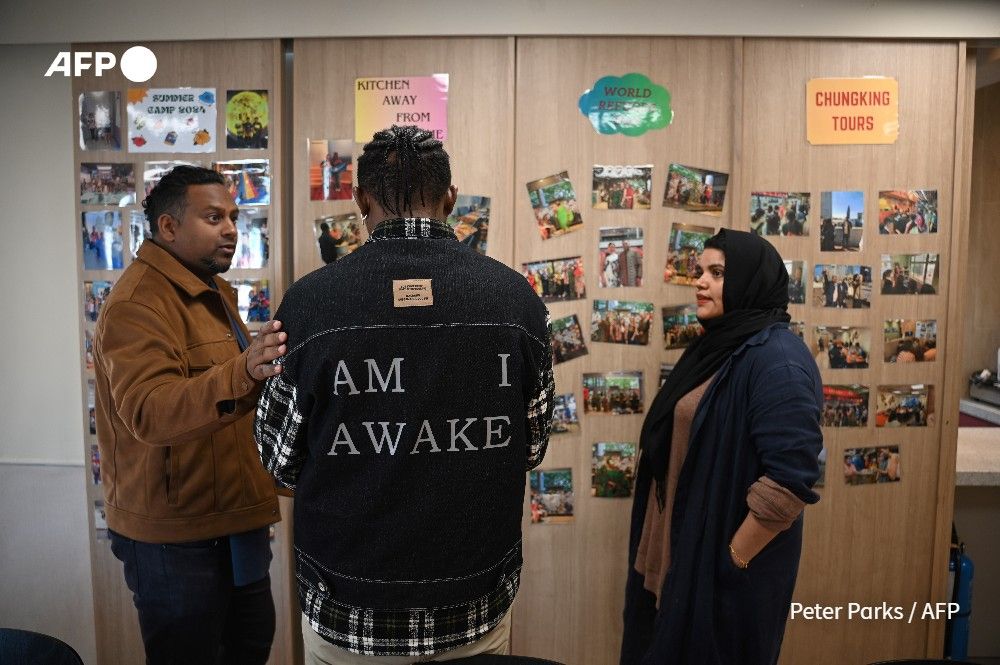 Photo taken on January 25, 2025 shows Uzma Naveed (R), an outreach coordinator, and social worker Jeffrey Andrews (L) speaking to ‘John’ (C) at the Christian Action Centre for Refugees in Chungking Mansions in Hong Kong. US President Donald Trump's executive order to suspend all refugee admissions and halt the US asylum programme, signed hours after taking office, has left adrift dozens in the Chinese city approved for US resettlement. (Peter Parks / AFP)