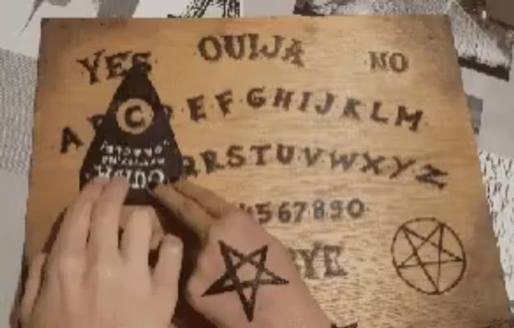 a person is using a wooden ouija board with a pentagram on it