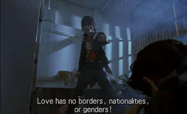 A still from the movie Wild Zero. Guitar Wolf, the lead singer, guitarist, and namesake of the Japanese punk band Guitar Wolf, yells “Love has no borders, nationalities, or genders!” at Ace, the protagonist.