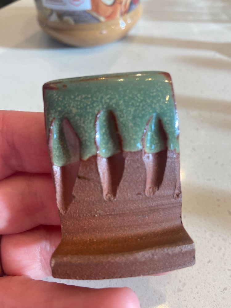 Green glaze with phase separation on brown clay test tiles. 