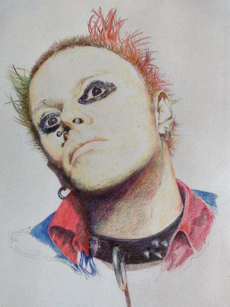 Picture of the late Keith Flint singer and Dancer with The Prodigy. Wearing a studded collar a banana bell seotum piercing black eye make up and pink and green, short reverse Mohican 