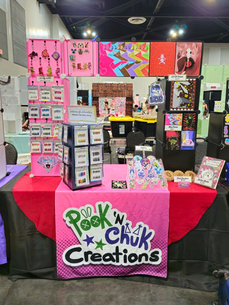 Pook N Chuk Creations table setup up: press-on nails, prints, stickers and charms galore!!