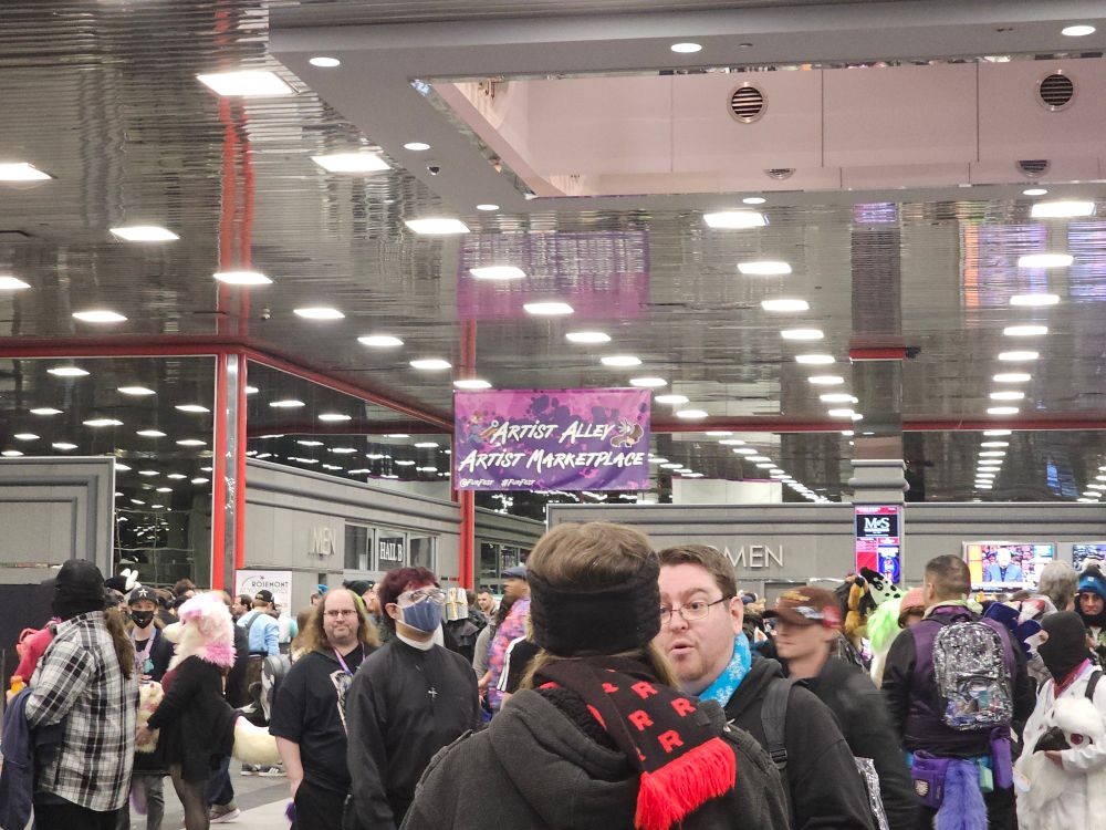 The sign for Midwest FurFest's Artist Alleh and Marketplace, above a crowd of con-goers