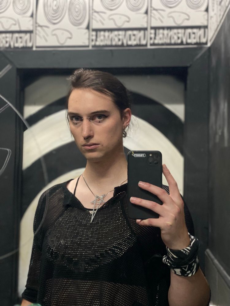 My friend Mare looking sternly at the camera holding up her phone 