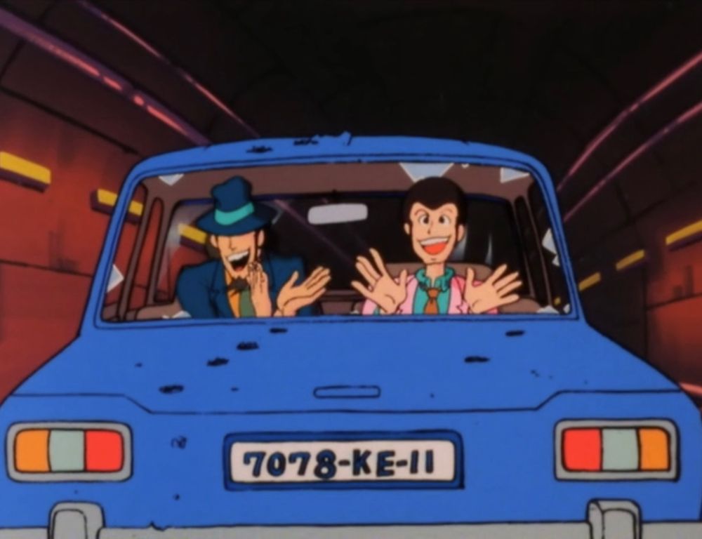 Two handsome men in a car, clapping their hands.