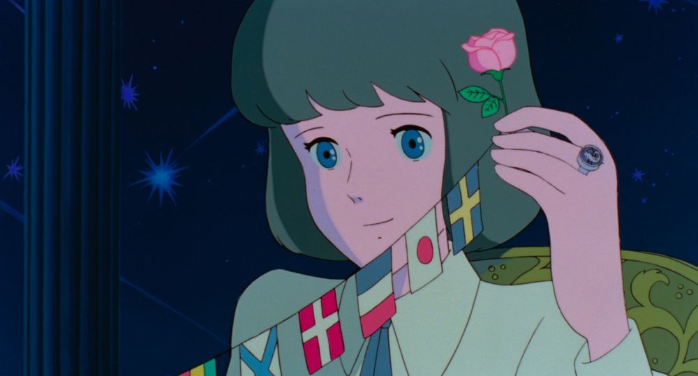 A young woman, holding a small pink flower and a string of world flags