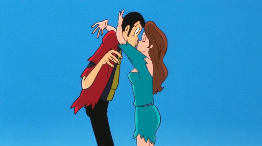A handsome man getting kissed by a beautiful woman. She's so enthusiastic, he looks surprised by it.