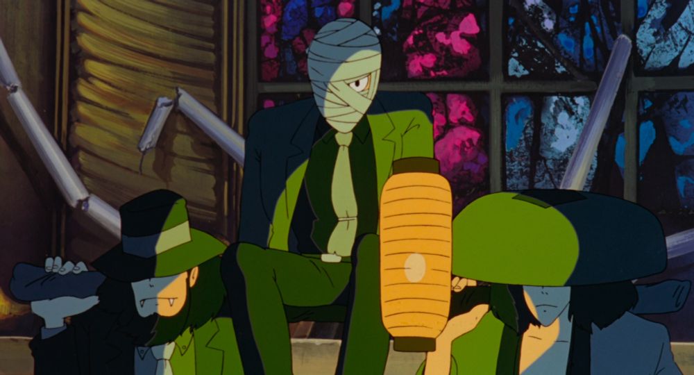 Three handsome men walking through a dark cathedral. The one on the left is wearing a fedora and has fangs. The one on the right is a samurai. The one in the middle's strikingly handsome face is covered in bandages.