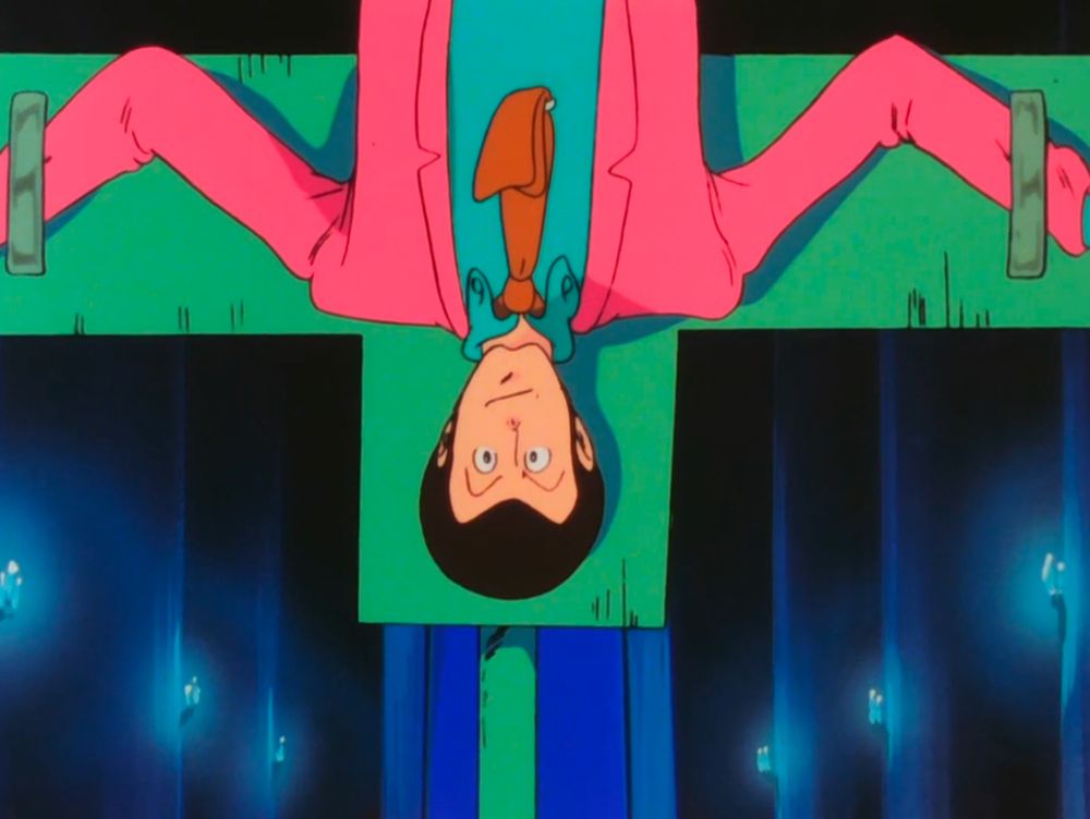 A handsome man in a pink jacket being held crucified upside down.