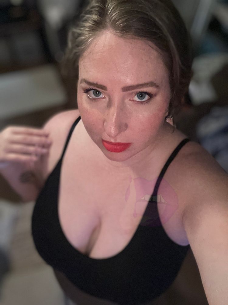 Lindy Myles' shows off her mesmerizing eyes in a selfie shot that highlights her voluptuous cleavage as she wears a black spaghetti strap top.