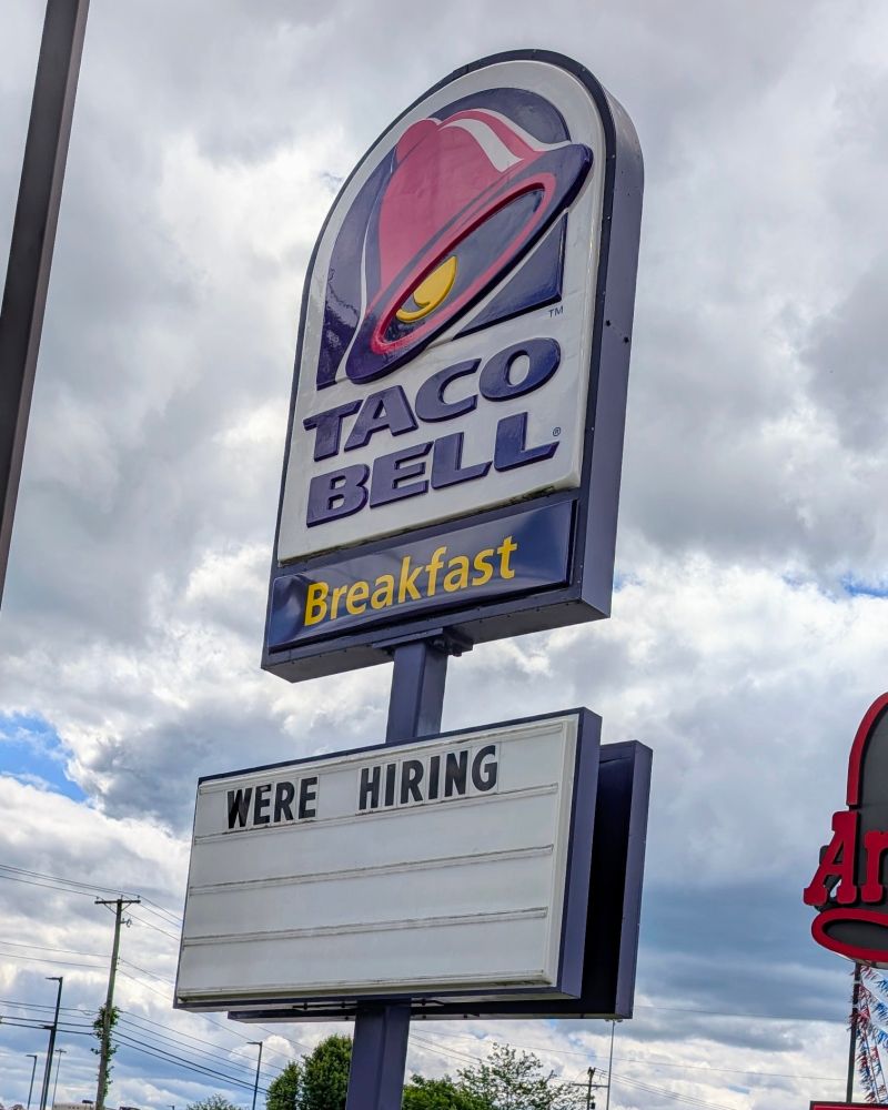 A Taco Bell sign that says "Were Hiring."