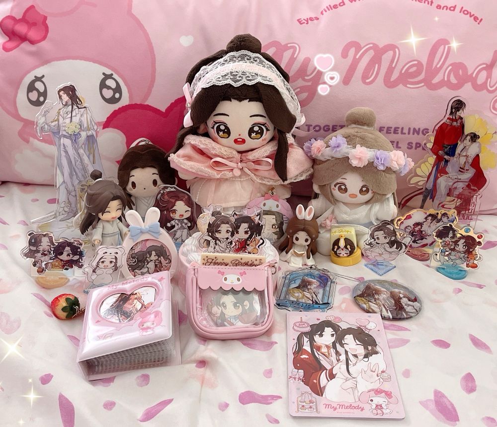 xie lian minidoll sits, surrounded by various other xie lian and hualian merchandise