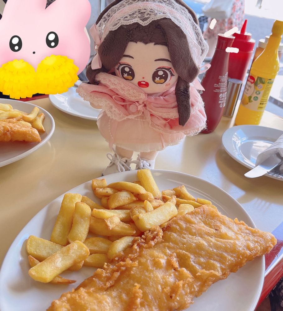 xie lian minidoll hovering over a plate of fish and chips