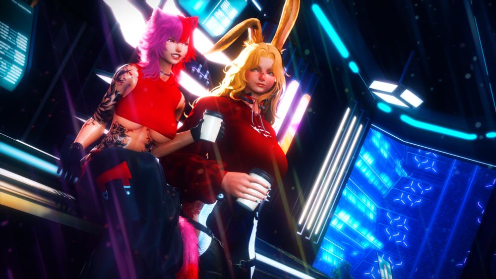 Rinoa, left, is wearing a red top and black pants. She is sitting on the counter at the S9 coffee shop. Kaiyle, right, is leaning up against the counter, wearing a different red shit and black pants. They both hold coffee with the view of S9 in the background. 