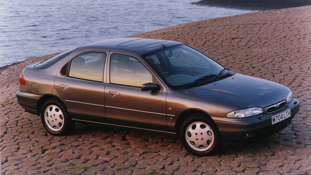 Mk1 Ford Mondeo in grey, on some cobbles next to the sea