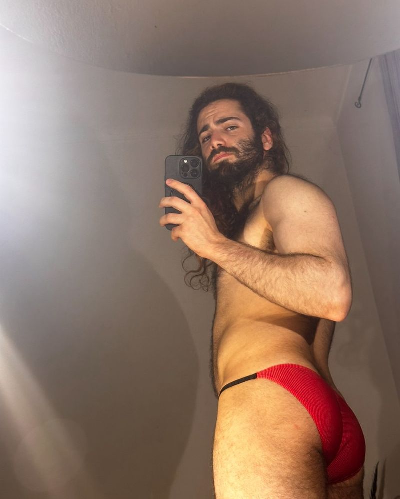 A picture of me, lightly hairy, wearing thin tight red underwear that compliment my ass and makes you want to give it a jiggle 