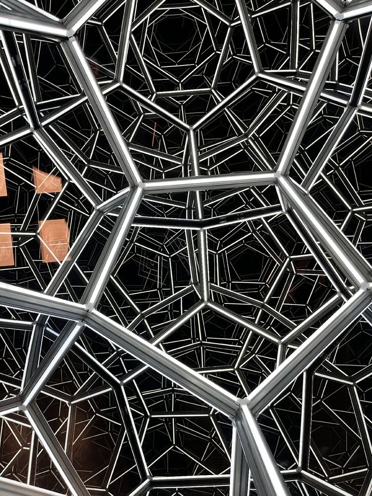 An optical illusion using a series of one way mirrors and white  lights to create a hexagonal shape that appears to go on into the distance.