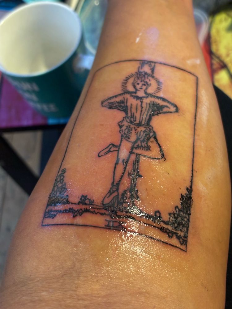 Image of freshly tattooed hanged man tarot card on a forearm. 