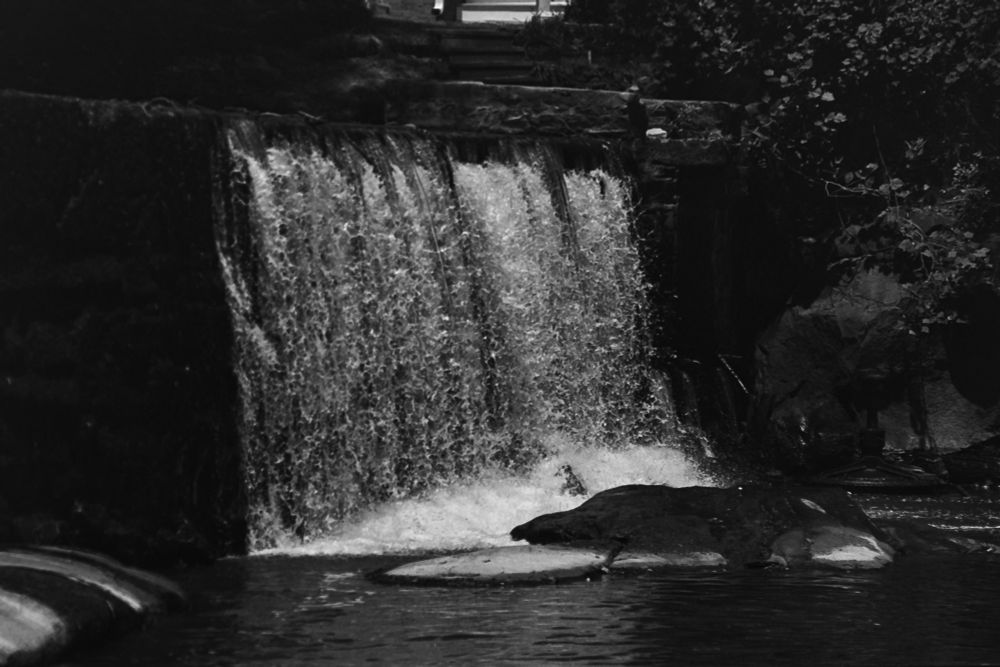 Black and white photograph of a waterfall. The shutter speed was set high to freeze the water droplets in motion.