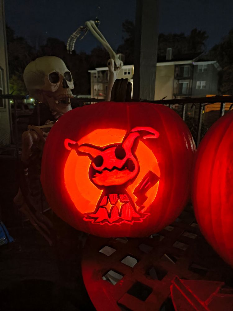 A carving of the pokemon mimikyu in a pumpkin