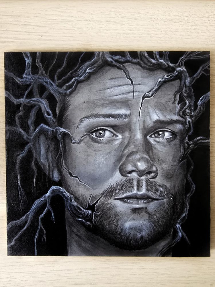 Surreal portrait painting of Sam Winchester's face (a character from the Supernatural TV show). His face has tree roots growing out of cracks in his skin. The painting is in greyscale, painted with acrylic inks. 