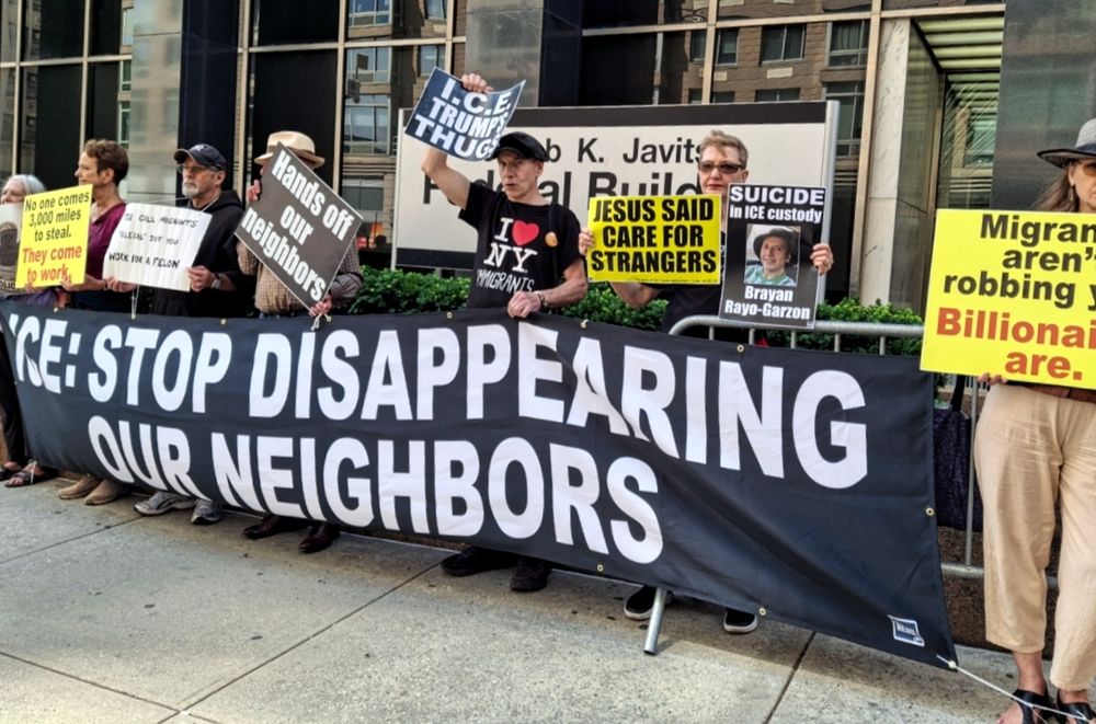 People with banner, signs at 26 Federal Plaza 