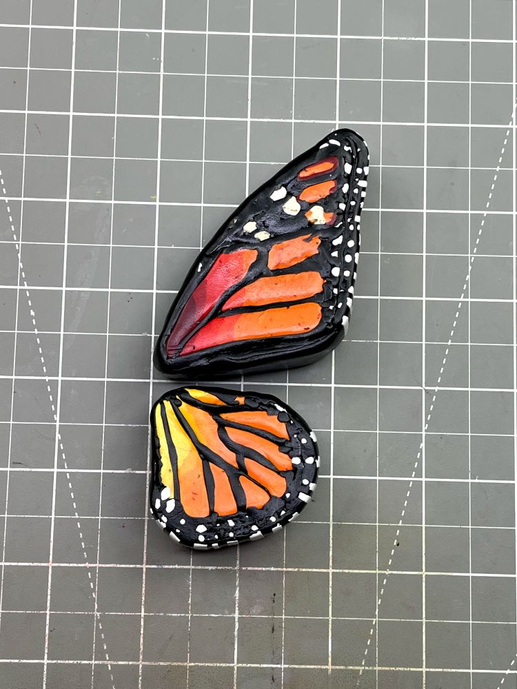 A top view of a large polymer clay butterfly wing. The rich fall colors and patterning are supposed to resemble that of a Monarch Butterfly.