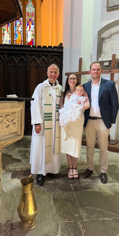 Rev’d Mark stood next to the font with baby Ellie and her parents 