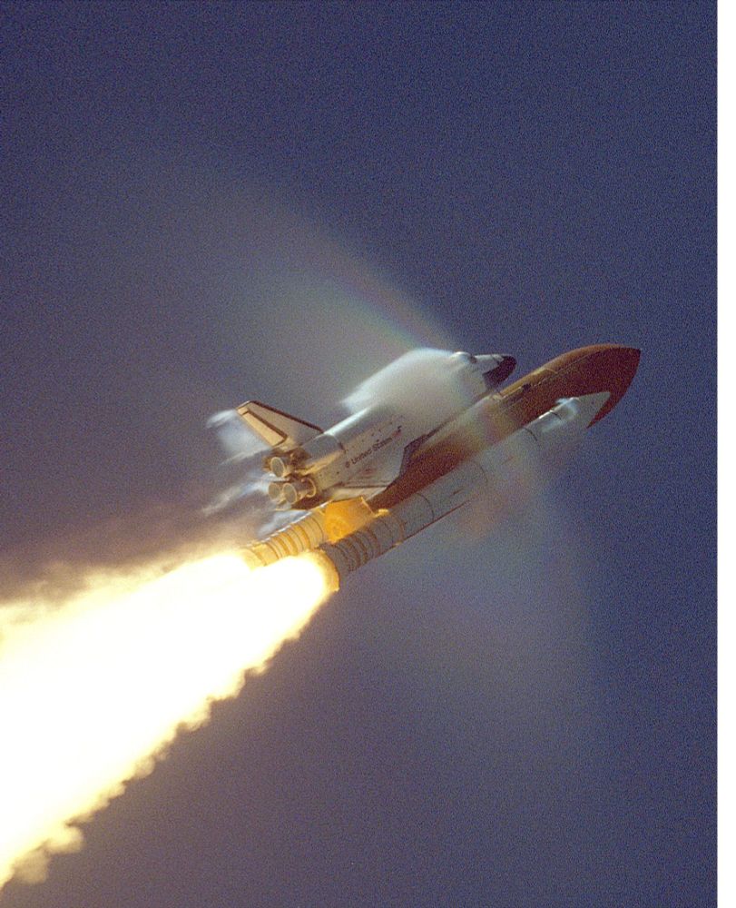 STS106-S-013 (8 September 2000)--- This view of shock-wave condensation collars backlit by the Sun occurred during the launch of the Space Shuttle Atlantis on September 8, 2000.  The scene was captured on 35mm motion picture film.  One frame was digitized to make this still image.  Although the primary effect is created by the forward fuselage of the Atlantis, secondary effects can be seen on the solid rocket booster (SRB) forward skirt, shuttle vertical stabilizer and wing trailing edge, behind the Space Shuttle Main Engines (SSME).