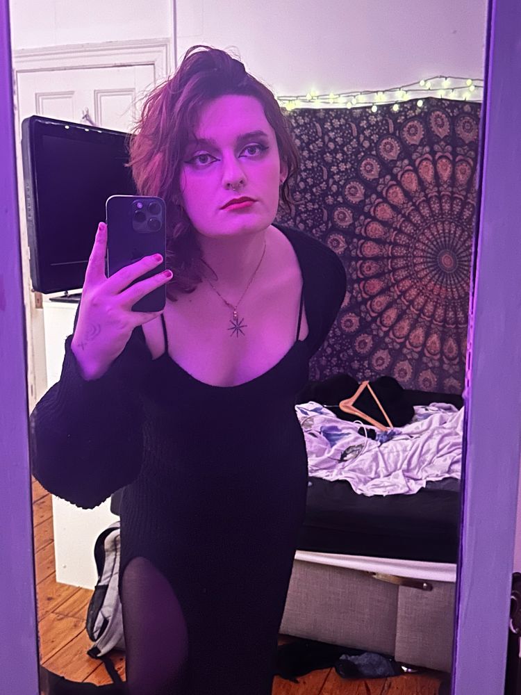 Eleanor in a black dress with purple lighting