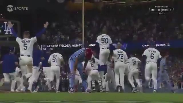 Orion Kerkering bent over with hands on knees in sadness while the Dodgers celebrate behind him
