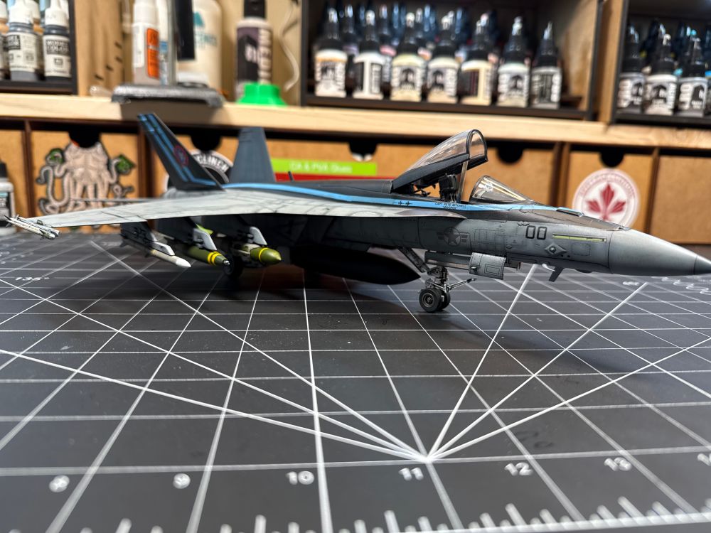 Front 3/4 view from the ground, looking at the cockpit, front landing gear, and the bomb & missile payload. 