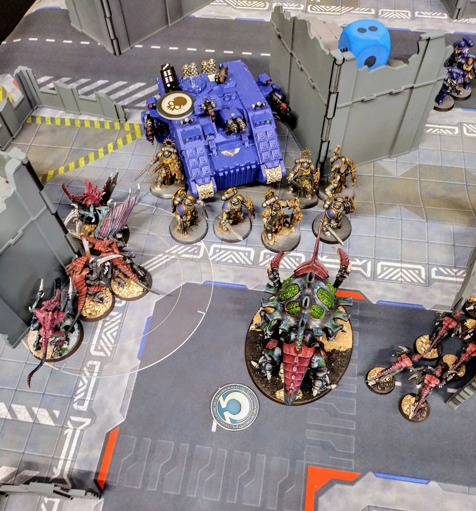 Ultramarine bladeguard, captain and land raider plough into the Tyranids in the middle of the board 