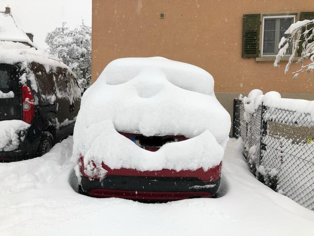 Der Schnee auf meinem Auto ist so verrutscht, dass es wie ein Gesicht aussieht. 