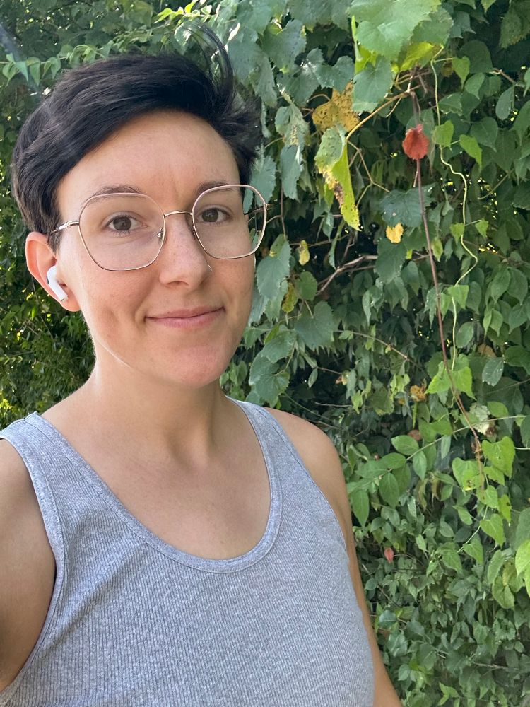 Picture of Mik taking a dog walk, in front of shrubbery 