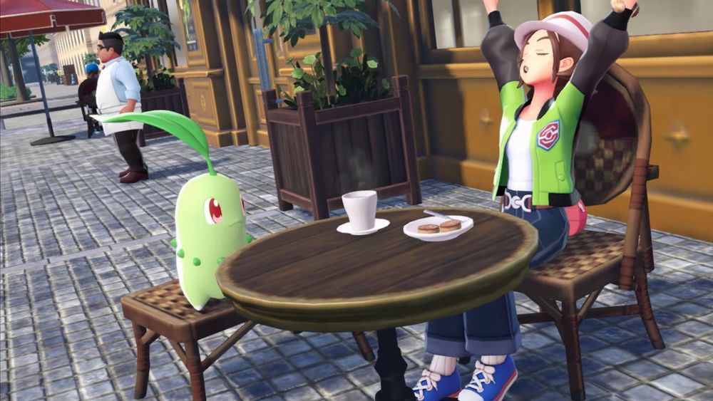 Screenshot of Pokemon Legends: Z-A from the March 27, 2025 Nintendo Direct. The player sits at a cafe table with Chikorita. On the table is a piping hot cup of something and some snacks.