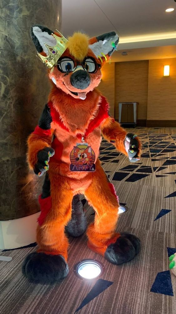 Fursuiter crouched all silly like looking at camera