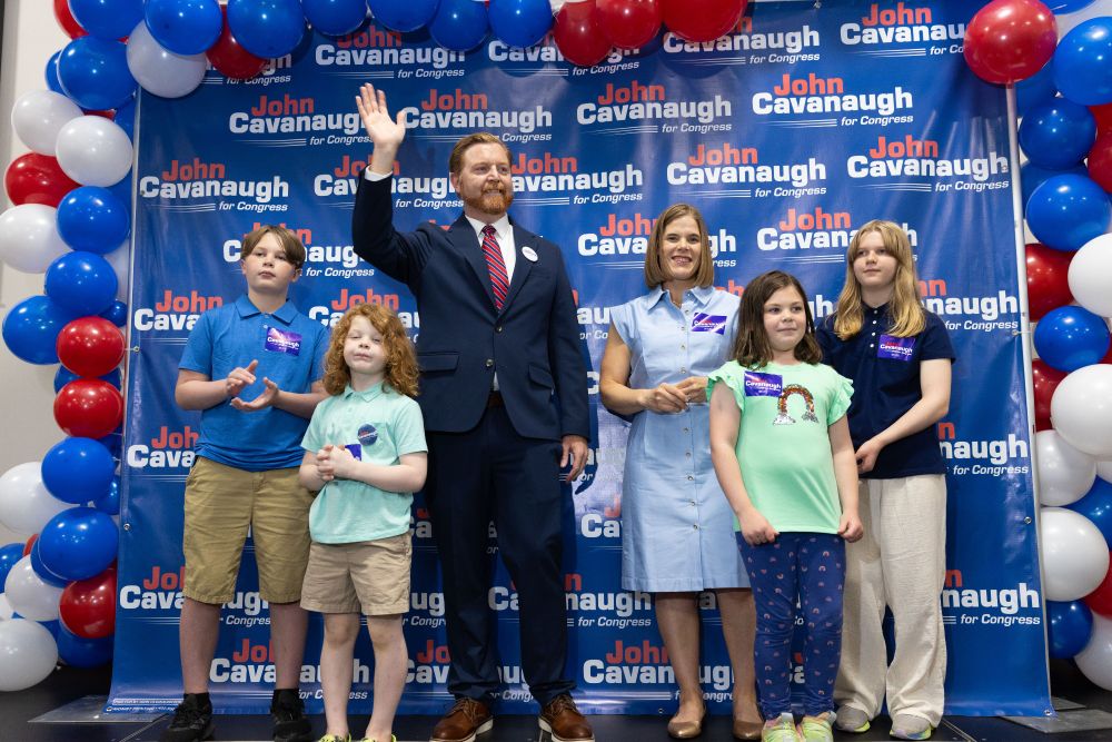 John Cavanaugh and his family stands on stage at his kickoff event