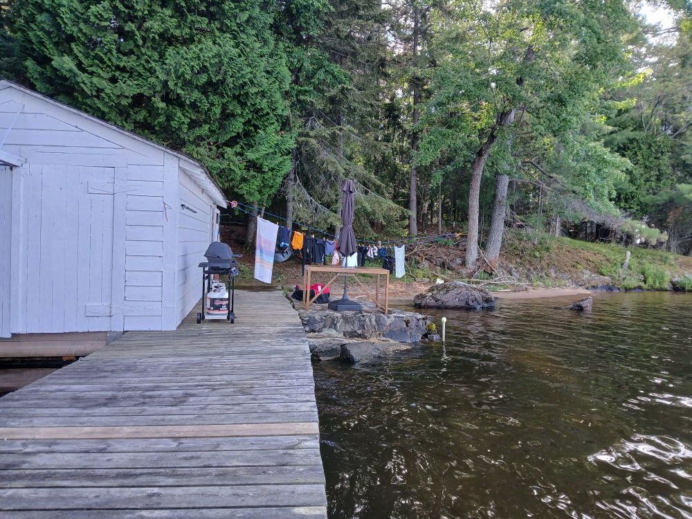 boathouse, dock, hockey gear on clothesline & near beach